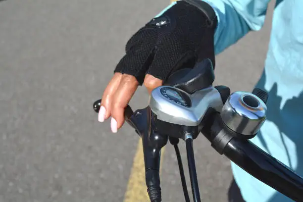 Photo of Woman hand with bright pink nails on the bicycle handle. Healthy life style concept. Hand holding bicycle handlebar.