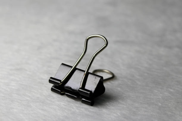 istock Black steel clip put on the white fabric floor. 901733526