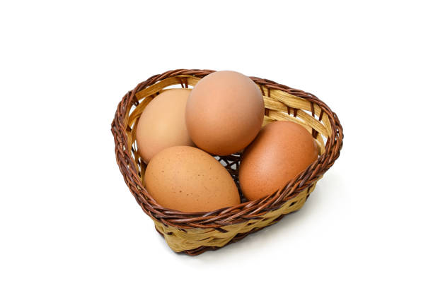 chicken eggs are in a heart shape basket on a white background