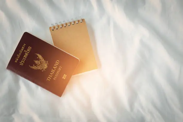 Thailand passport and notebook on bed with copy space,Travel Planning and Travel memory concept