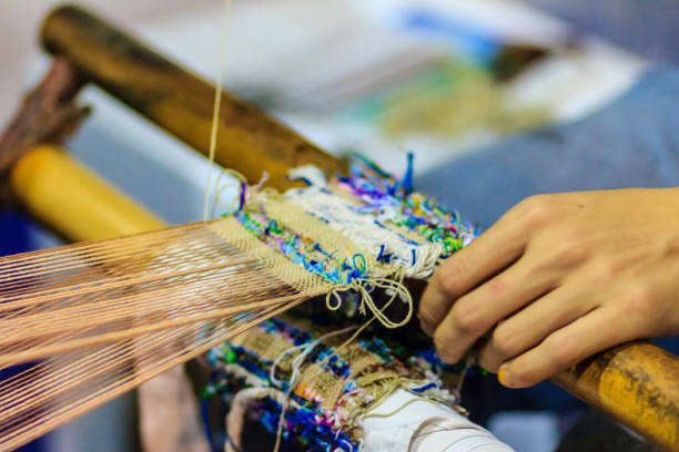 istock Weaver using small loom or weaving machine for weaving fabric. Weaver is weaving show and teaching to the tourist at the night market. 901769346