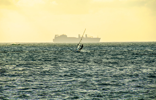 US navy ship and wind surfer off the coast of Saipan. Northern Mariana Islands, Micronesia. Western Pacific Ocean.