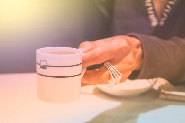 istock Female hands holding coffee cup over dark table 901776274