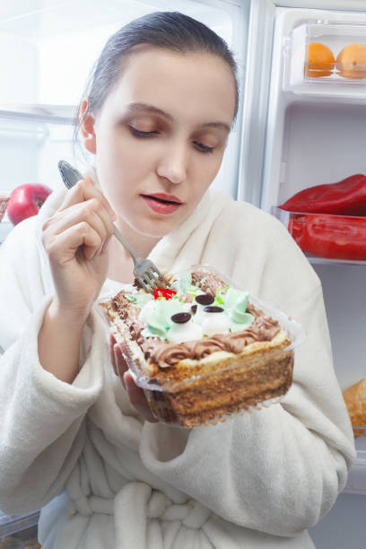 istock hungry woman eating 901779848