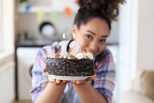 istock Woman holding birthday cake with candles 901780724