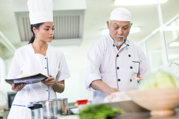 istock Chef and assistant preparing asian food in restaurant's kitchen 901780772