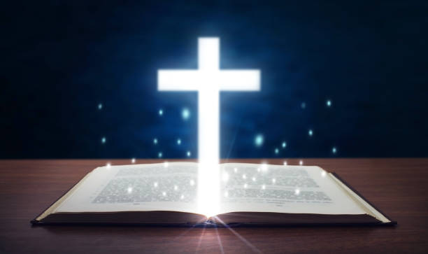 istock Holy bible with glowing cross. 901781214