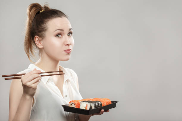 donna che mangia sushi - triteleia ixioides foto e immagini stock
