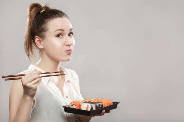 istock woman eating sushi 901784006