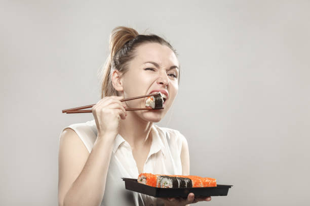 istock woman eating sushi 901784026