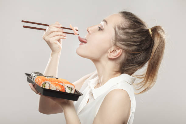 istock woman eating sushi 901784082
