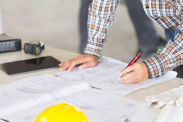istock Management consulting with engineers working with blueprint and drawing on work table in for management business plan and construction site project. 901788734