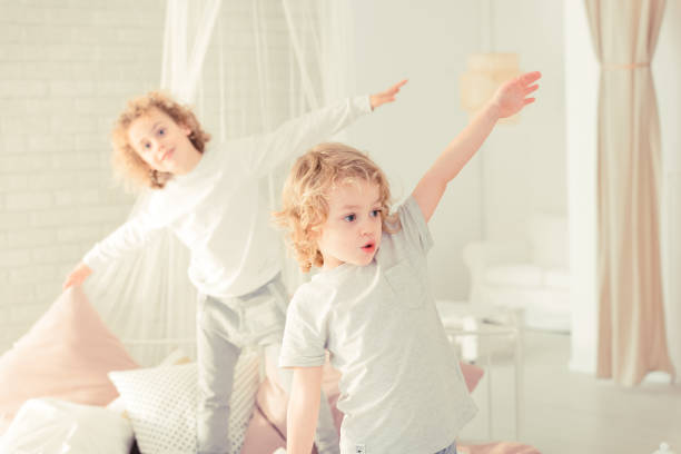 istock Brothers standing on the bed 901789908
