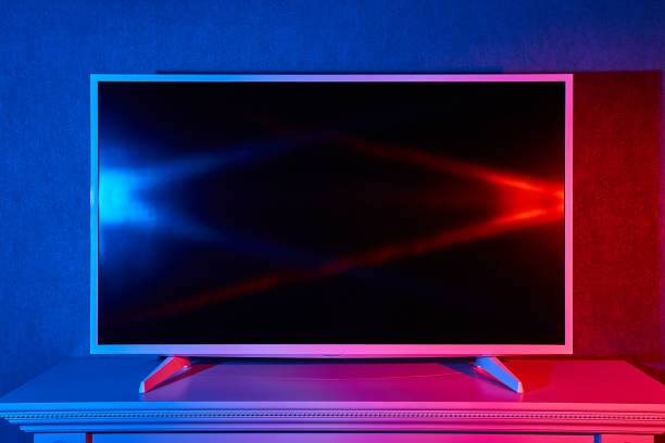 A flat TV lit with red and blue colors stock photo