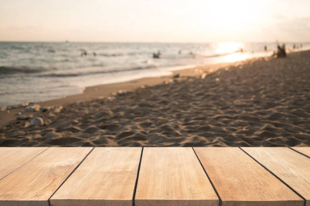 istock Empty wooden table and blurred  sunset beach background 901797358