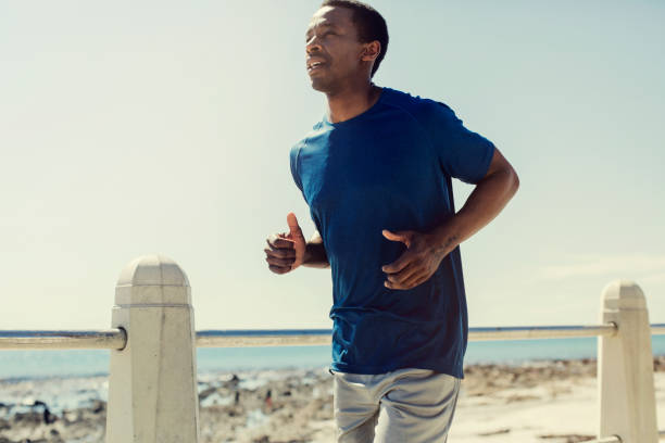 istock Sportsman jogging by railing against clear sky 901801870