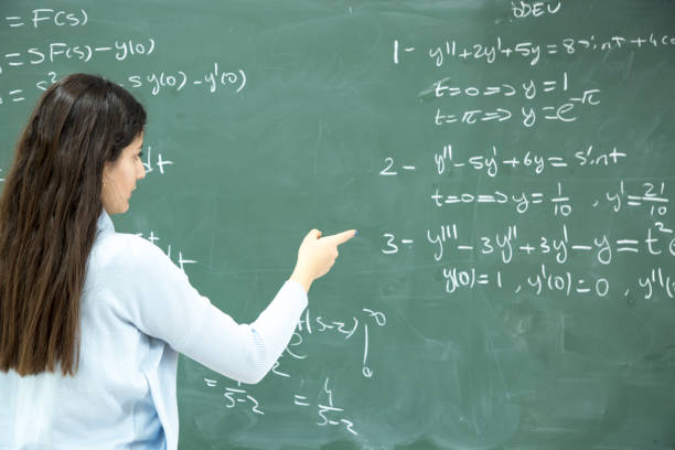istock Female Student writing mathematical formula in front of the blackboard 901810004