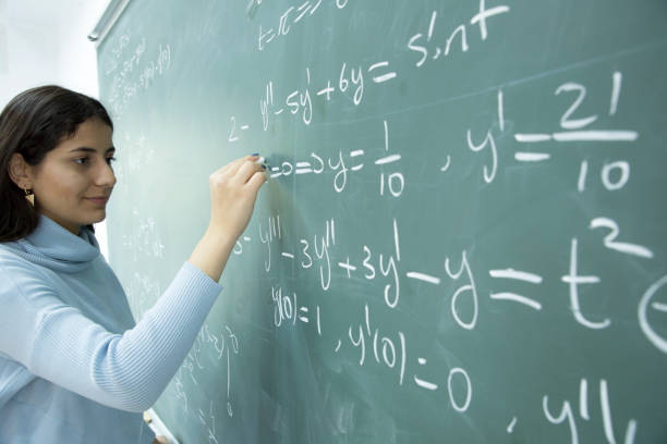 istock Female Student writing mathematical formula in front of the blackboard 901810042