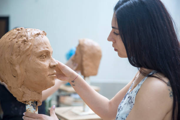 istock Artist working on clay sculpture in art studio 901814154