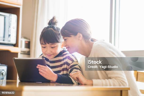 Mother And Daughter Playing With A Digital Tablet In Room Stock Photo - Download Image Now