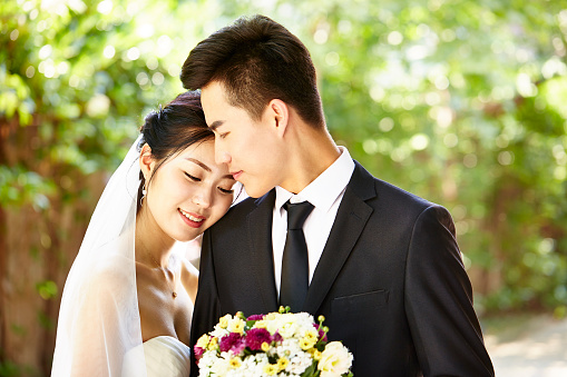 young asian bride and groom kissing at wedding ceremony