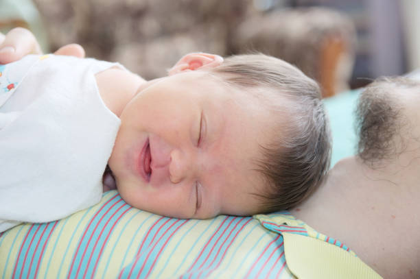 istock Sleeping newborn baby happy smiling portrait on father 901816980