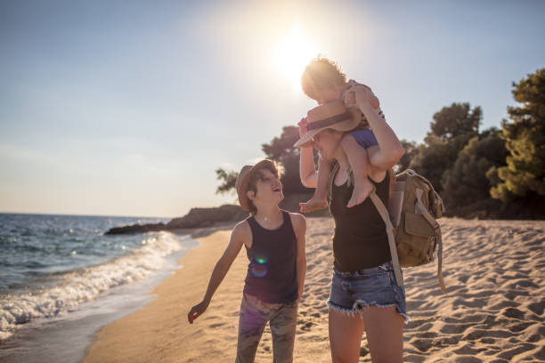 Mother with two son walking at the beach