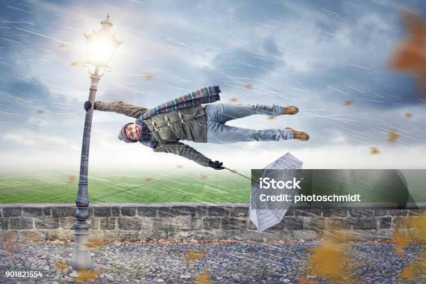 Man Gets Blown Away By A Storm Stock Photo - Download Image Now - Wind, Storm, Humor