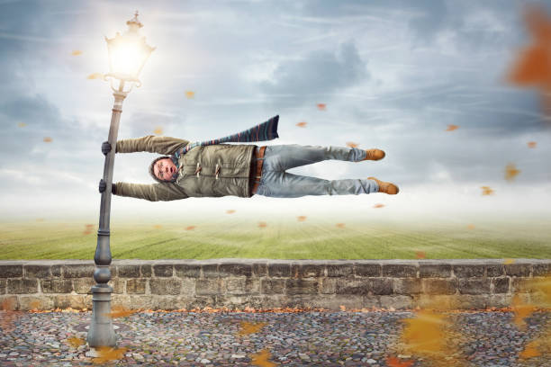 A young woman is falling as if flying through the air in front of a blue sky background.