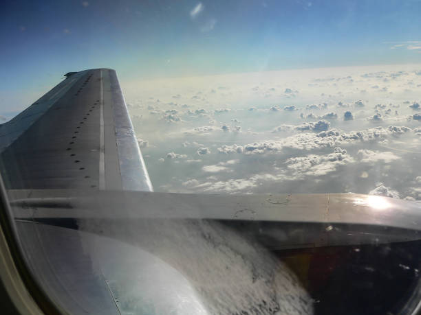 istock Beautiful dramatic clouds and blue sky from aero plane window with aircraft engine 901827678