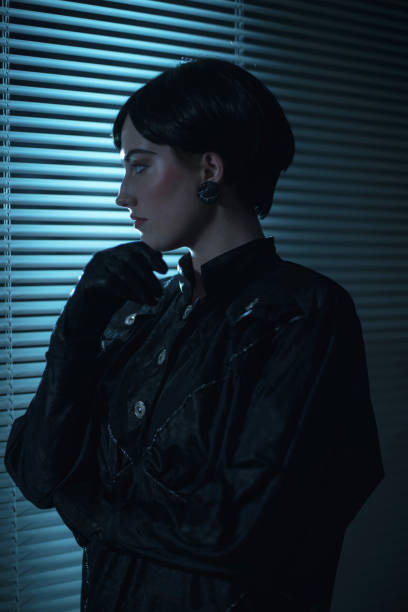 istock Retro 80s business woman looking through blinds at night. 901828064