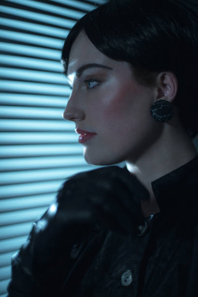 istock Retro 80s business woman looking through blinds at night. 901828070