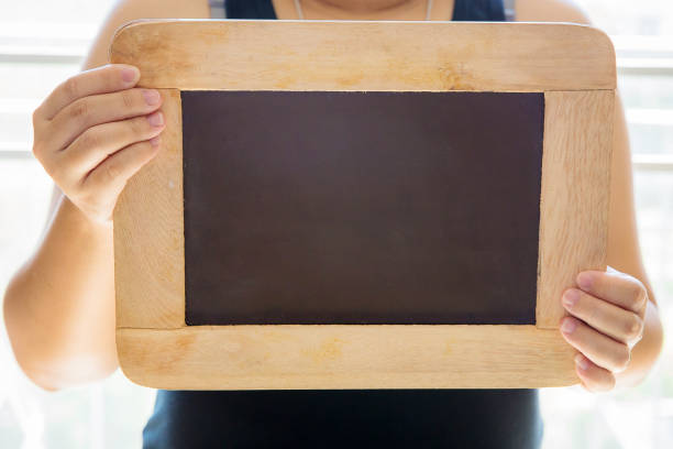 istock pregnant woman hold small black chalkboard. FAQ concept. 901830506