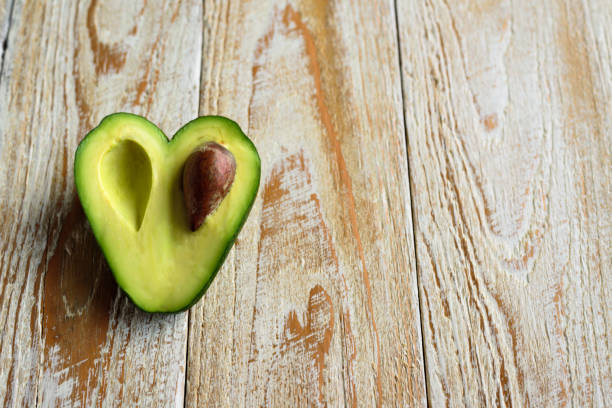 istock Heart shaped avocado on wooden background 901838692