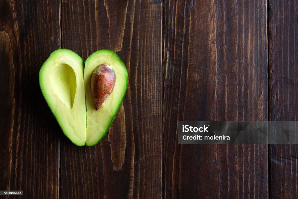 Aguacate en el fondo de madera en forma de corazón - Foto de stock de Aguacate libre de derechos