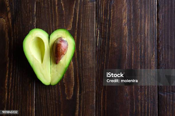 Foto de Coração Em Forma De Abacate Sobre Fundo De Madeira e mais fotos de stock de Abacate - Abacate, Símbolo do Coração, Comida
