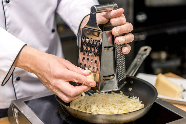 istock cropped image of chef grating cheese on grater 901847316