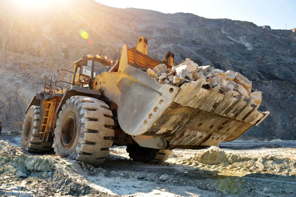 istock Wheel loader machine unloading rocks in the open-mine of iron ore 901847824