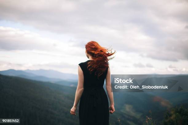 Woman In Black Dress Walking In The Mountains And Looking At View Stock Photo - Download Image Now