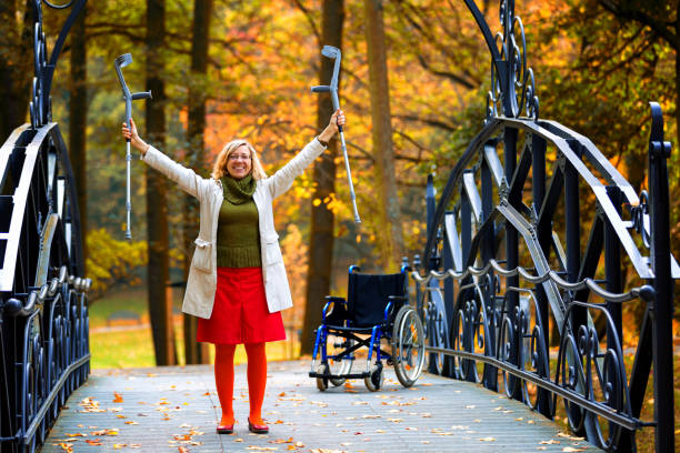 handicapped woman raising her crutches stock photo