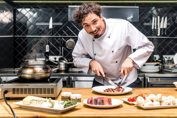 istock smiling chef cutting fried meat with knife and fork 901851680