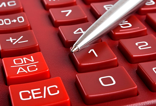 Red calculator and pen, close up