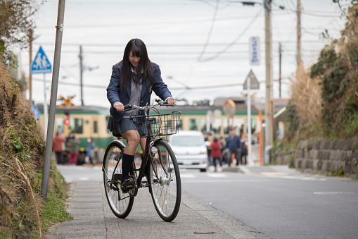 High school girl riding bicycle on slope