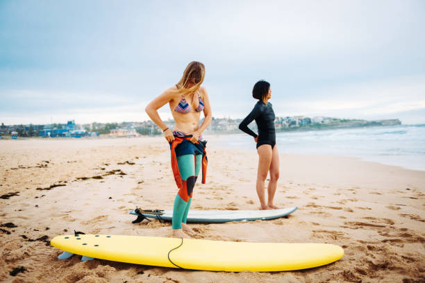 istock Two females preparing for morning surfing session 901858300
