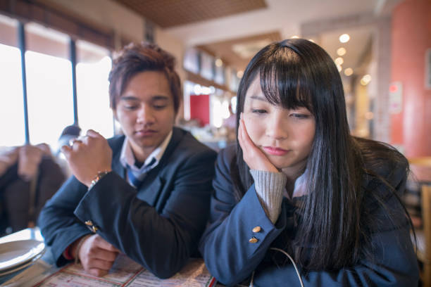 istock High school student couple looking at menu in restaurant 901858400