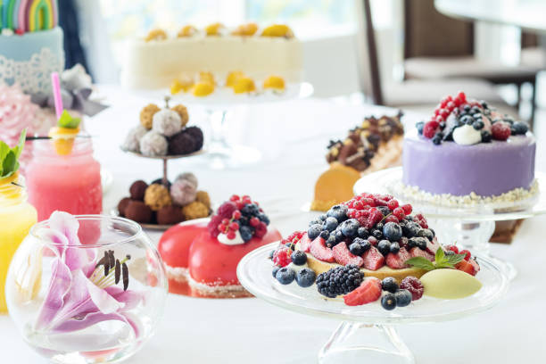 istock Many sweet pastries on white table with fresh summer berries. Festive table settings. Light background. Shallow depth of field 901861510