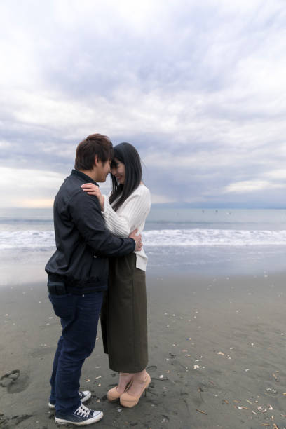 istock High school student couple holding each other on beach 901862162