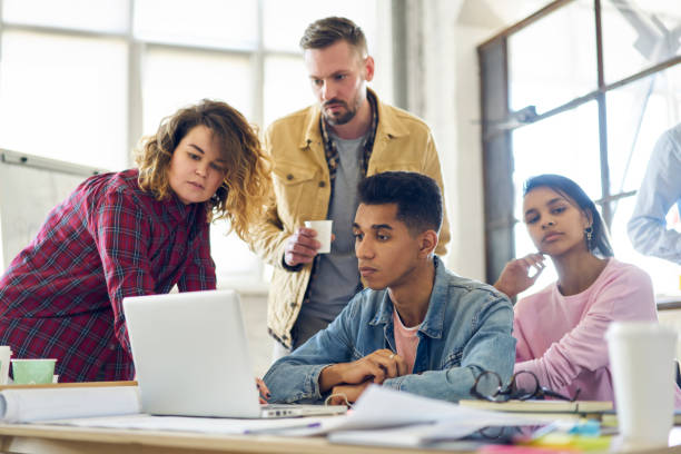 équipage de stagiaires mâles et femelles regarder webinaire de formation sur le web de modélisation pour améliorer les compétences et les connaissances dans la conception, de collègues, tester la convivialité d’une application innovante sur ordinateur portable - lundi noir chinois photos et images de collection