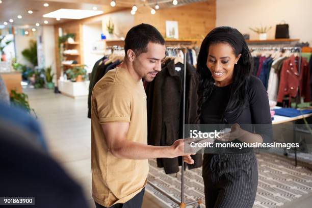 Sonriente Pareja Con Tablet Pc En Una Tienda De Ropa Foto de stock y más banco de imágenes de Venta al por menor