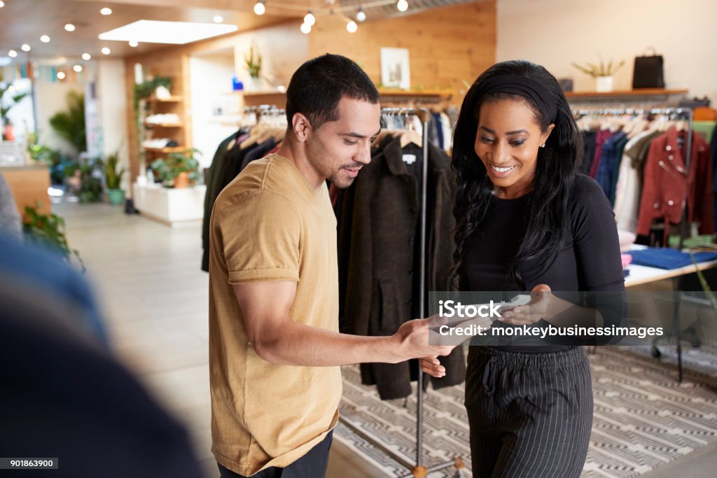 Couple souriant, à l’aide de tablet PC dans un magasin de vêtements - Photo de Commerce libre de droits
